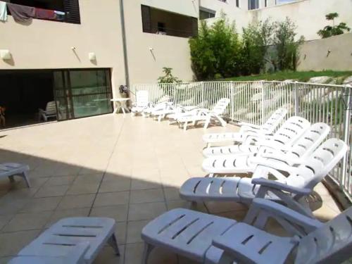 a group of white chairs sitting next to a building at Appartement en centre-ville d’Uzès in Uzès