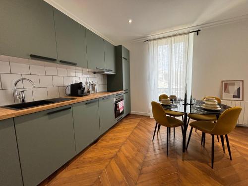 une cuisine avec une table et des chaises dans une cuisine dans l'établissement Le Rêveur - Parking Gratuit, Wifi, RER C Choisy-le-Roi, à Choisy-le-Roi