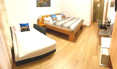 a room with two beds and a table and a desk at Hotel Garni Villa Areka in Český Krumlov