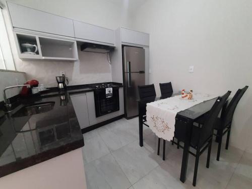 a kitchen with a table and chairs and a kitchen with a refrigerator at Apartamento Aconchego nas Montanhas, em Cunha-SP in Cunha