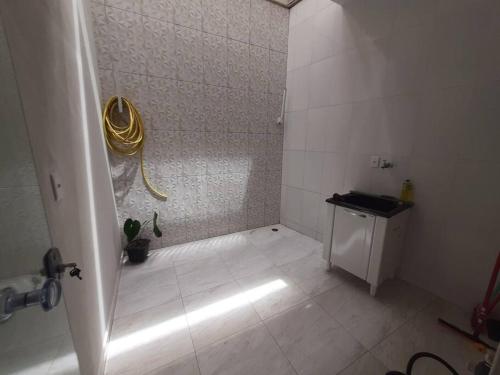 a bathroom with a shower with a yellow hose at Apartamento Aconchego nas Montanhas, em Cunha-SP in Cunha