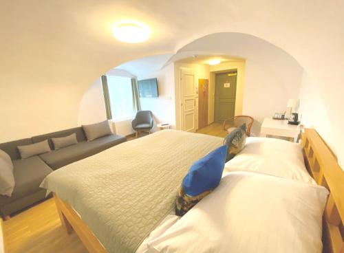 a large bedroom with two beds and a couch at Hotel Garni Villa Areka in Český Krumlov
