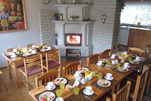 a dining room with two tables and a fireplace at Pärna Guesthouse & Apartments in Kuressaare