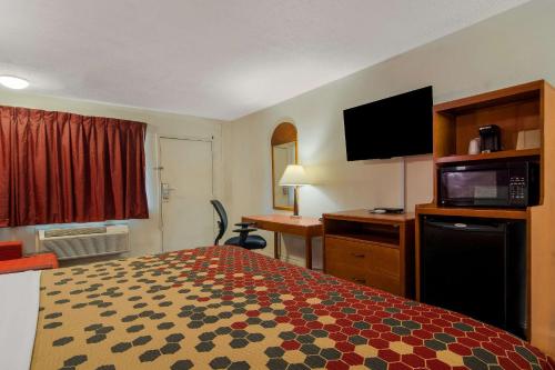 a hotel room with a bed and a flat screen tv at Econo Lodge Goldsboro Hwy 70 in Goldsboro