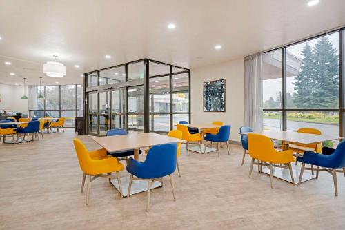 Una cafetería con mesas, sillas y ventanas. en Comfort Suites Idaho Falls, en Idaho Falls