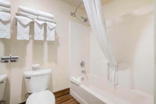 a white bathroom with a toilet and a bath tub at Comfort Inn Troutdale-Portland East in Troutdale