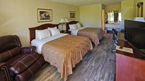 a hotel room with two beds and a couch at Quality Inn in Ennis