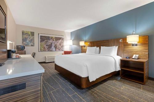 A bed or beds in a room at The Lux Hotel & Conference Center, Ascend Hotel Collection