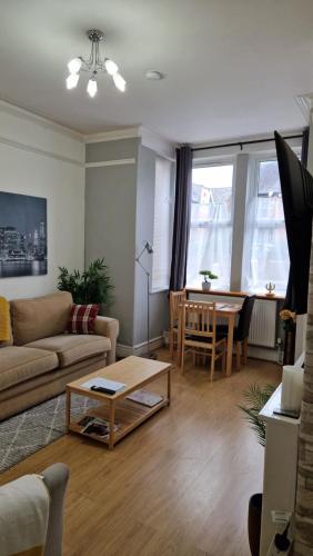 een woonkamer met een bank en een tafel bij Spacious 1 Br Near Lincoln City Centre Amenities in Lincoln