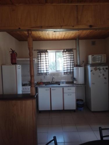 cocina con electrodomésticos blancos y nevera blanca en PALIHUE en Sierra de la Ventana