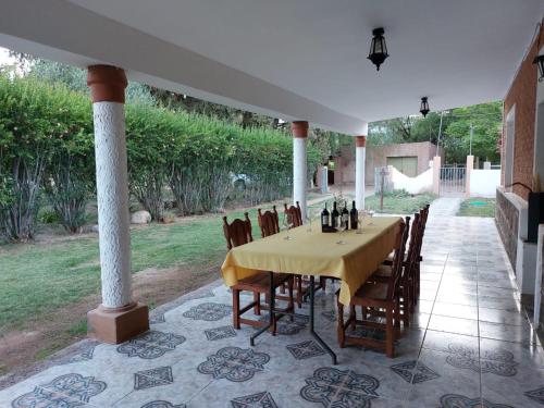 a dining room with a table and chairs on a patio at BODEGA Y ALOJAMIENTO DON VEGA in Tinogasta