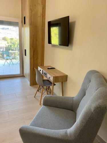 a living room with a couch and a table and a television at Lemnos Urban Escape in Mirina