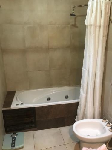 ein Badezimmer mit einer Badewanne, einem WC und einem Waschbecken in der Unterkunft La Tapera in Guaymallen
