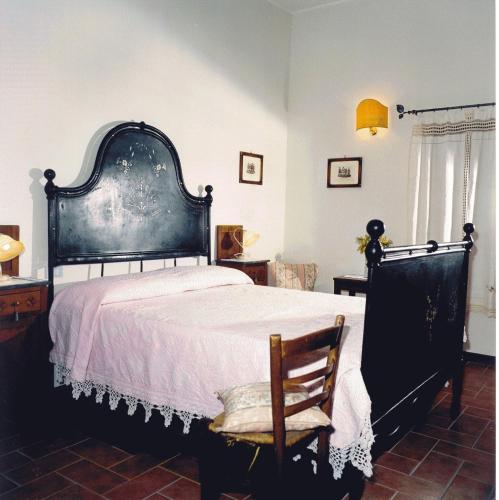 a bedroom with a large bed and a chair at Il Borgo Agriturismo in Ferentillo