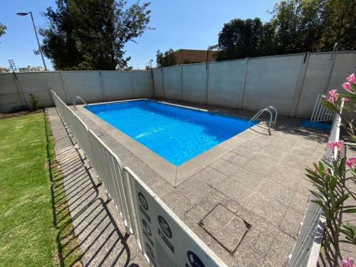 una piscina en un patio trasero con una valla en Alto Las Condes - A pasos del Mall - Excelente y cómodo Departamento p/2 personas en Santiago