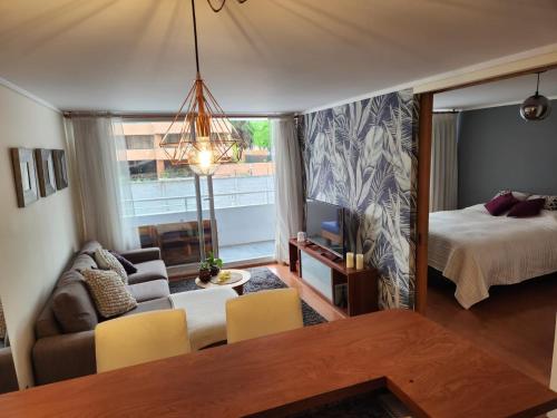 - un salon avec un canapé, un lit et une télévision dans l'établissement Alto Las Condes - A pasos del Mall - Excelente y cómodo Departamento p/2 personas, à Santiago