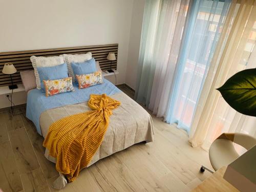 Un dormitorio con una cama con una manta amarilla. en Bien comunicado, acogedor y confortable en Coslada