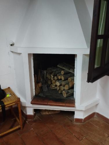 a fireplace with a pile of logs in it at casa vacanze cettina home 3 mt 50 dal mare in Terra Mala