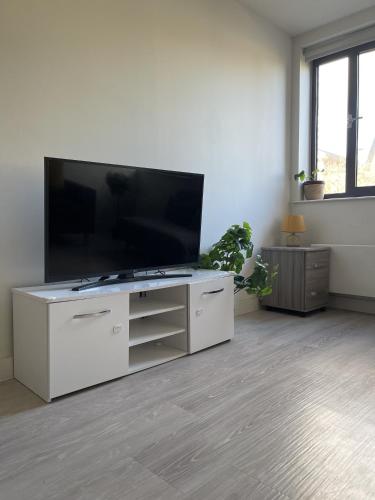 uma sala de estar com uma grande televisão de ecrã plano em Large Suite - Bedford City Centre em Bedford
