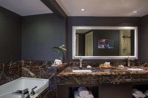 a bathroom with a tub and a large mirror at Renaissance Raleigh North Hills Hotel in Raleigh