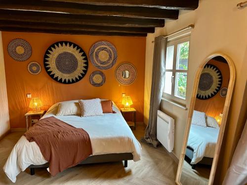 a bedroom with orange walls with a bed and a window at Ferme Marie Hélène in Ittlenheim