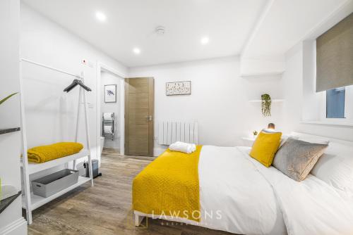 ein weißes Schlafzimmer mit einem großen Bett und gelben Kissen in der Unterkunft Central Living by Lawsons in Windsor