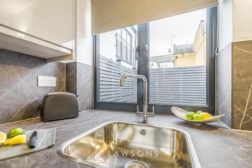 eine Küche mit einem Waschbecken und einem Fenster in der Unterkunft Central Living by Lawsons in Windsor