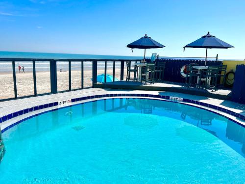 uma piscina com a praia ao fundo em Beach Happy - Ocean View at Symphony Beach Club em Ormond Beach