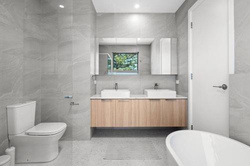 a bathroom with a toilet and a sink and a tub at Driftwood Port Noarlunga South in Port Noarlunga South