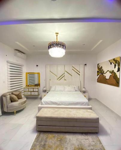 a bedroom with a large bed and a chandelier at Urban Retreat Luxury Shortlet Apartment Lekki Lagos in Lekki