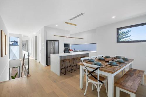 a kitchen and dining room with a table and chairs at Driftwood Port Noarlunga South in Port Noarlunga South
