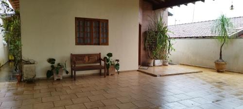 a living room with a chair and potted plants at Recanto do Bem-Te-Vi in Olímpia