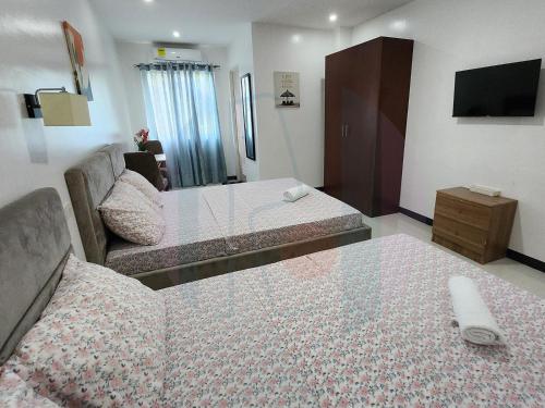 Habitación de hotel con 2 camas y sofá en RiCres Hometel Double Bed R124 en Samal