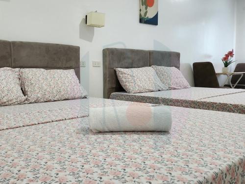 duas camas sentadas uma ao lado da outra num quarto em RiCres Hometel Double Bed R124 em Samal
