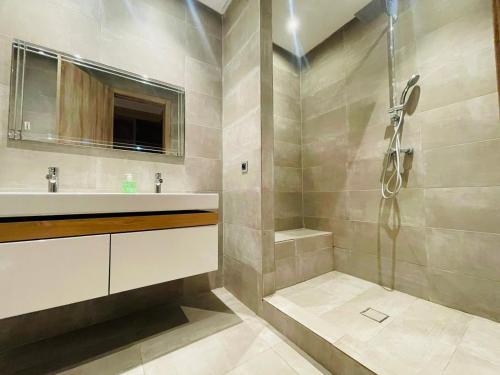 uma casa de banho com um lavatório e um chuveiro em luxury Villa with pool next mall em Dar Bouazza