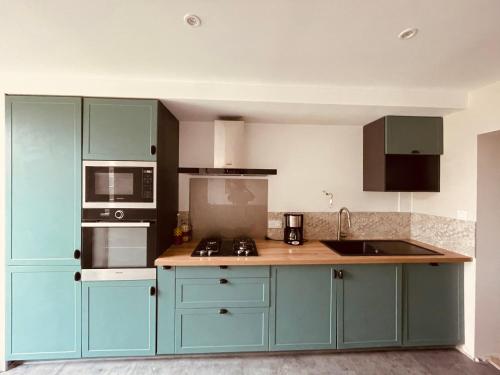 a kitchen with blue cabinets and a counter top at Maison 4 chambres in Saint-Pol-de-Léon