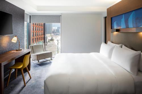 a hotel room with a bed and a desk and a window at Aloft Denver Downtown in Denver