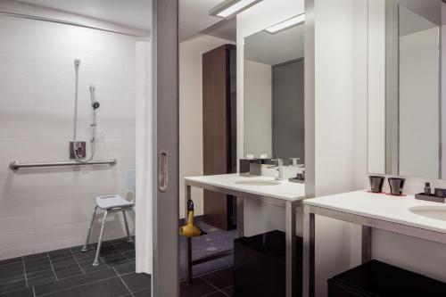 a bathroom with two sinks and a shower at Aloft Denver Downtown in Denver