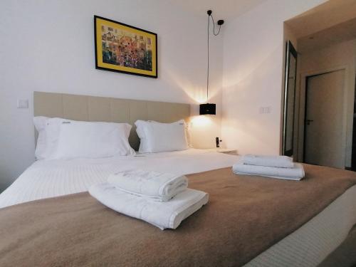 a bedroom with two white towels on a bed at Coimbra Monumentais B&B in Coimbra