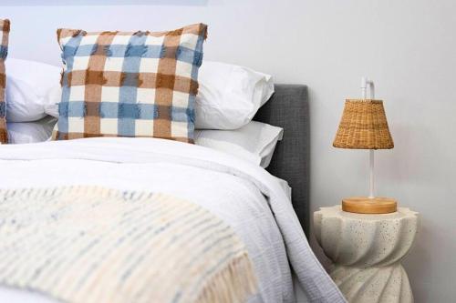 a bedroom with a bed and a lamp on a night stand at Esplanade Elegance Seaford: Sleeps 7 in Seaford