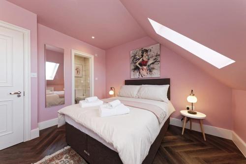 a bedroom with pink walls and a large bed at The Eagles in Kent