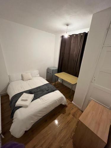 a bedroom with a bed and a table in it at Nice Battersea Flat in London