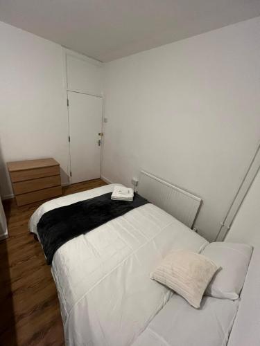 a bedroom with a white bed with a phone on it at Nice Battersea Flat in London