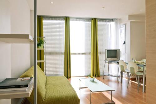 a living room with a couch and a table at Apartamentos La Pergola Castellón in Castellón de la Plana