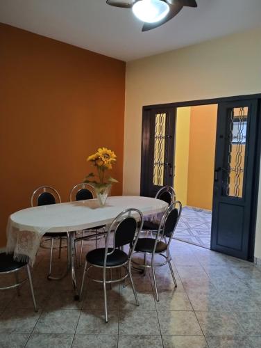 - une salle à manger avec une table, des chaises et une porte dans l'établissement Casa de Bençãos de Aparecida., à Aparecida