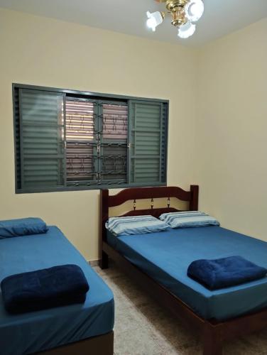 1 dormitorio con 2 camas y ventana en Casa de Bençãos de Aparecida., en Aparecida