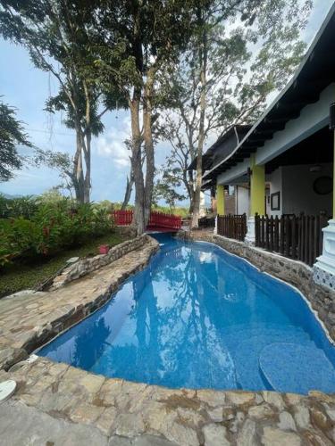 a blue swimming pool in a yard next to a house at Alpinas Montecarlo in Ostumán