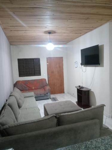sala de estar con sofá y TV de pantalla plana en Casa para temporada en Pirenópolis