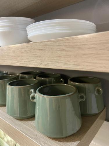 a shelf with cups and plates on top of it at Veľký apartman in Karlova Ves