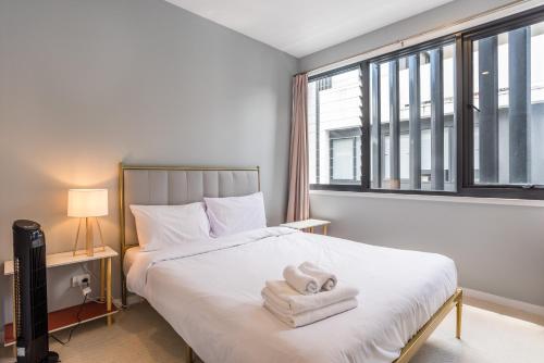 a bedroom with a bed with two towels on it at Westend 3 bedroom Split level Townhouse Next to River in Brisbane